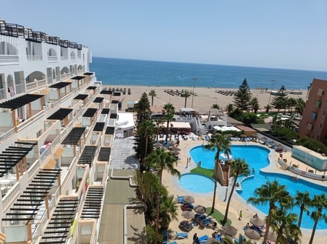 una vista aérea de un hotel con piscinas y palmeras