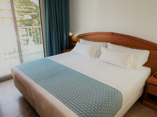a hotel room with a bed and a blue blanket