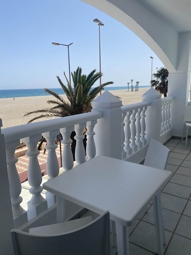 a balcony with a table and chairs overlooking the beach