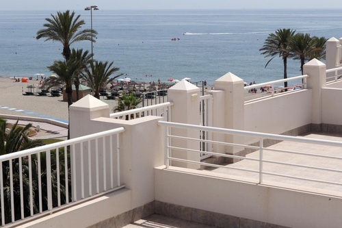 a view of the ocean from a balcony with a white railing