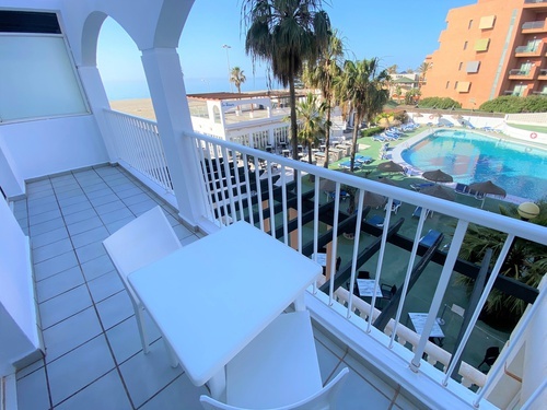 a balcony with a table and chairs overlooking a swimming pool