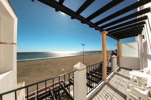 a balcony with a view of the beach and ocean