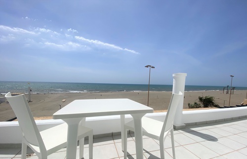 a table and chairs on a balcony overlooking the ocean