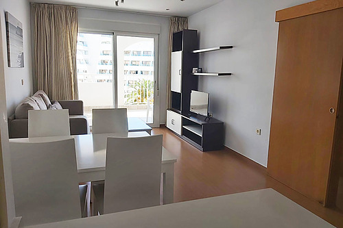 Modern hotel room with living area, dining table, sofa, and TV. Bahia Serena