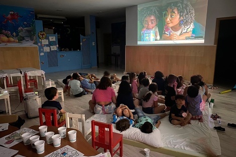 un grupo de niños miran una película en una pantalla