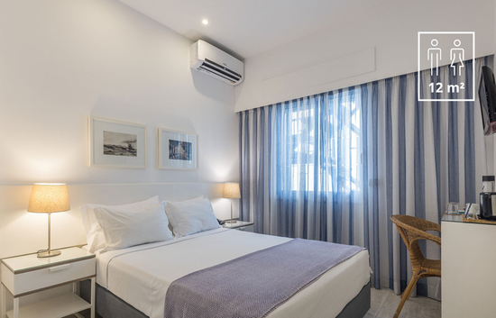 a hotel room with a king size bed and blue and white curtains