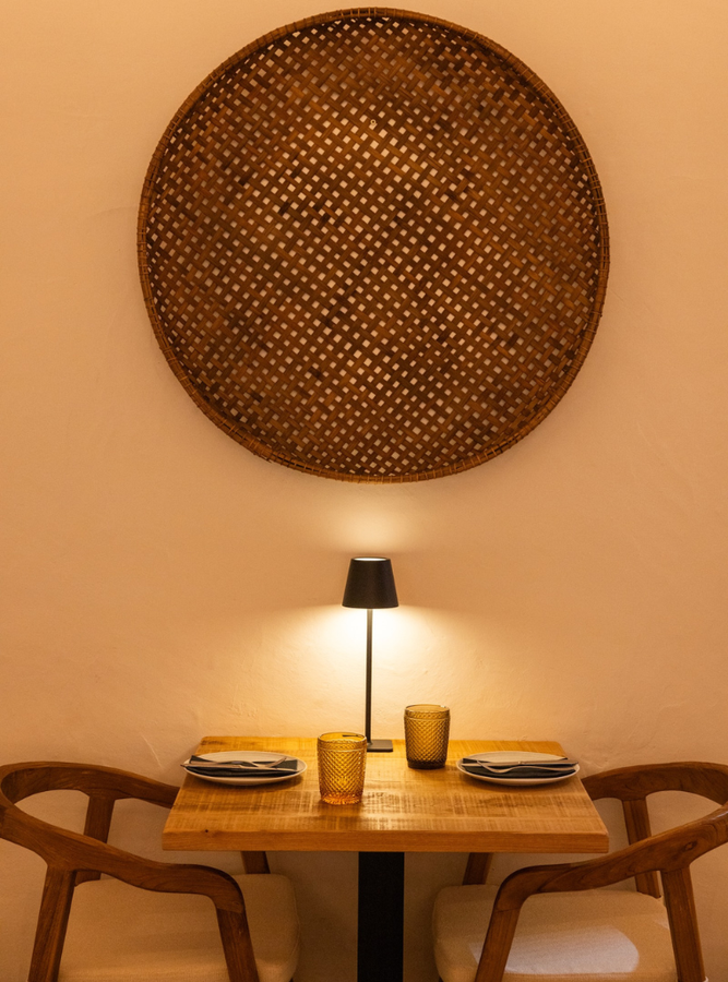 a table with plates and glasses and a lamp on it