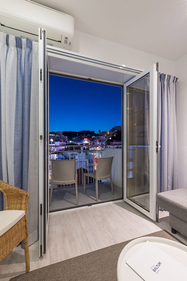 Hotel Baltum: Habitación con balcón y vistas nocturnas a la ciudad.