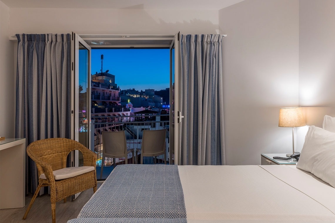 a hotel room with a view of a city at night