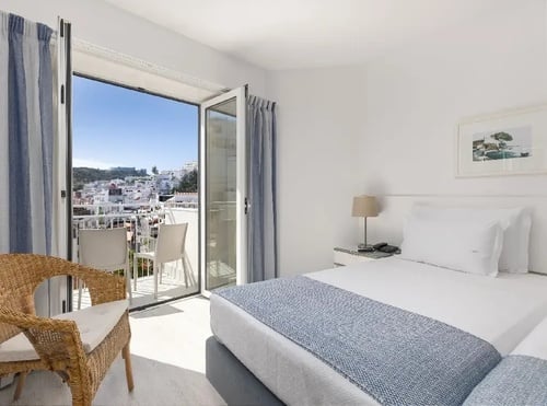 um quarto com duas camas e uma varanda
