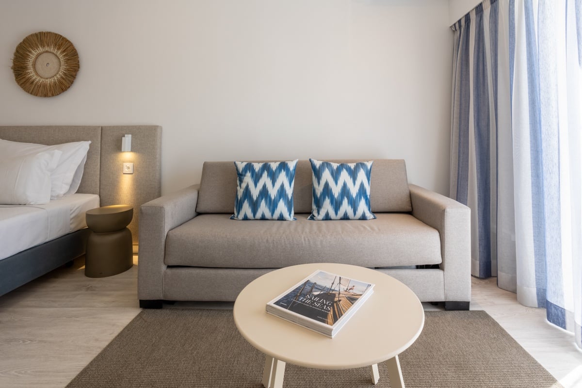 Hotel Baltum rooms: Bright hotel room with a sofa, bed, and nautical-themed decor.
