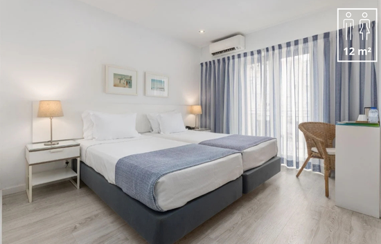 una habitación de hotel con dos camas y una mesa