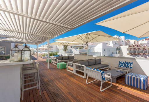 una terraza de madera con muebles y sombrillas