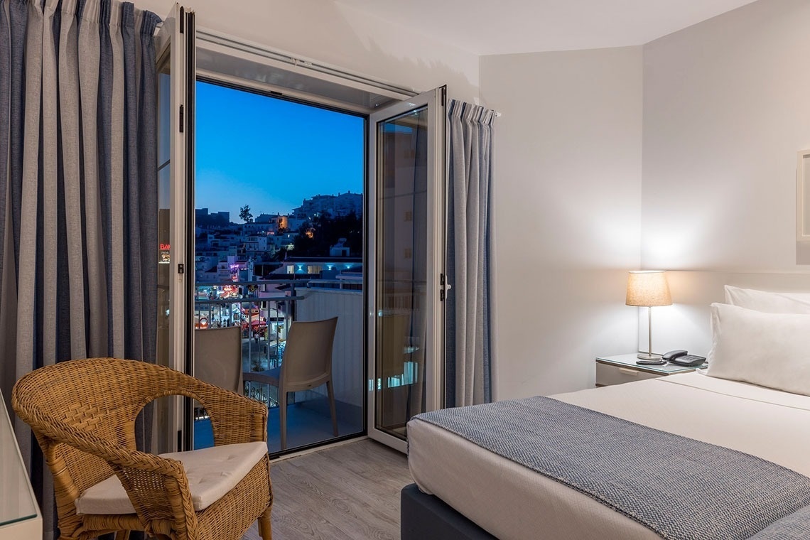 a hotel room with a wicker chair and a bed