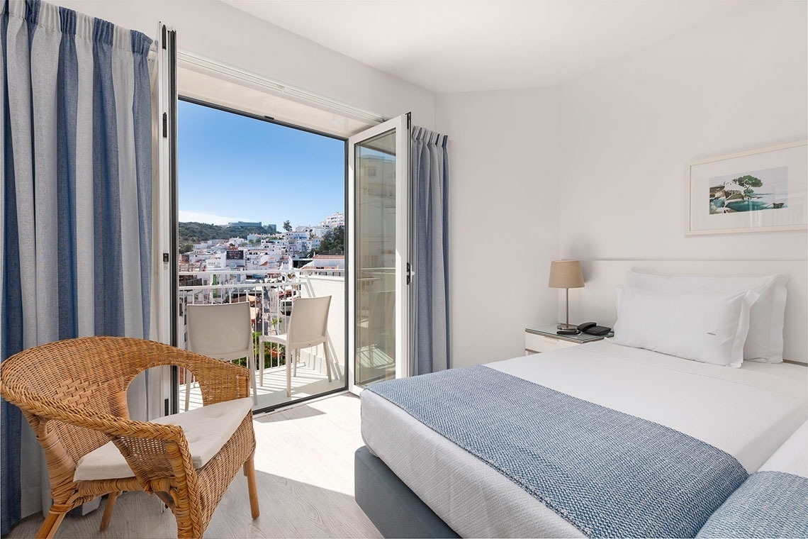 a hotel room with two beds and a balcony