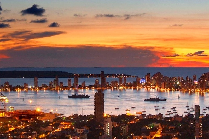 una ciudad al atardecer con muchos barcos en el agua