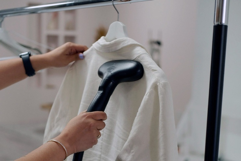 una persona limpia una camisa blanca con un vaporizador