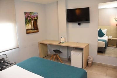 una habitación de hotel con una cama y una televisión