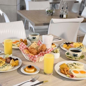 a table topped with plates of food and drinks including orange juice
