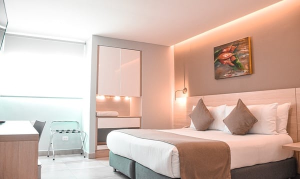 una habitación de hotel con una cama y una pintura en la pared