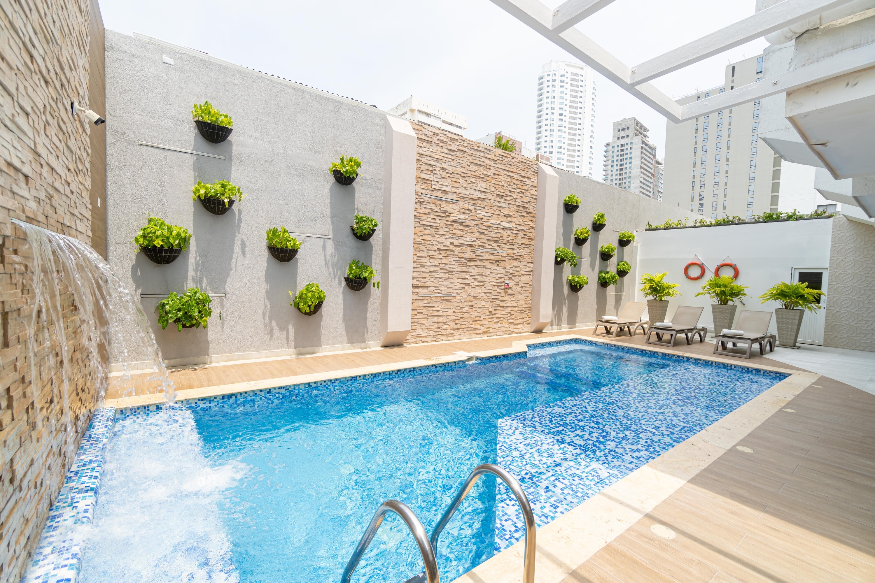 una piscina con escaleras y una cascada en la pared