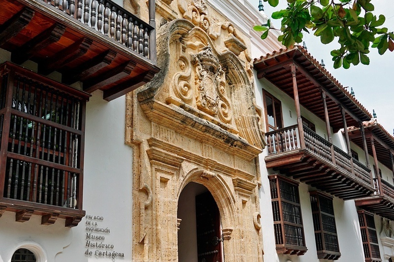 un edificio blanco con balcones de madera y la palabra museo histórico de cartagena en la puerta