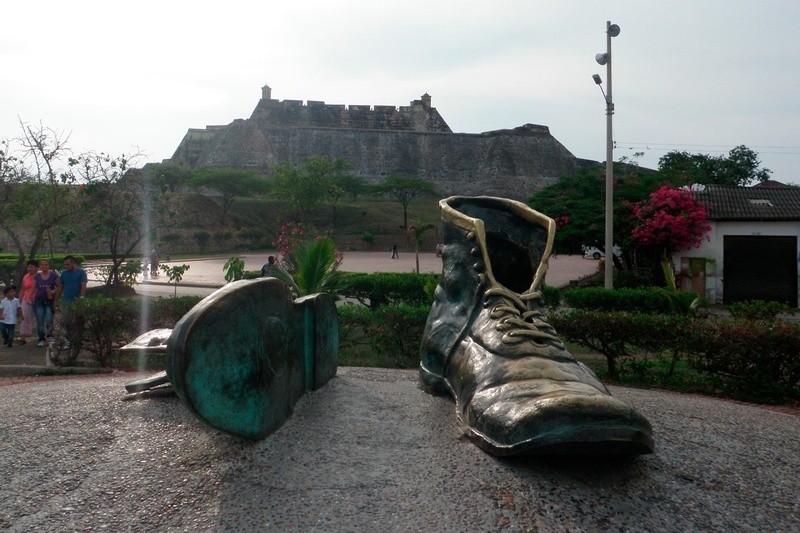 una estatua de un zapato con un castillo en el fondo