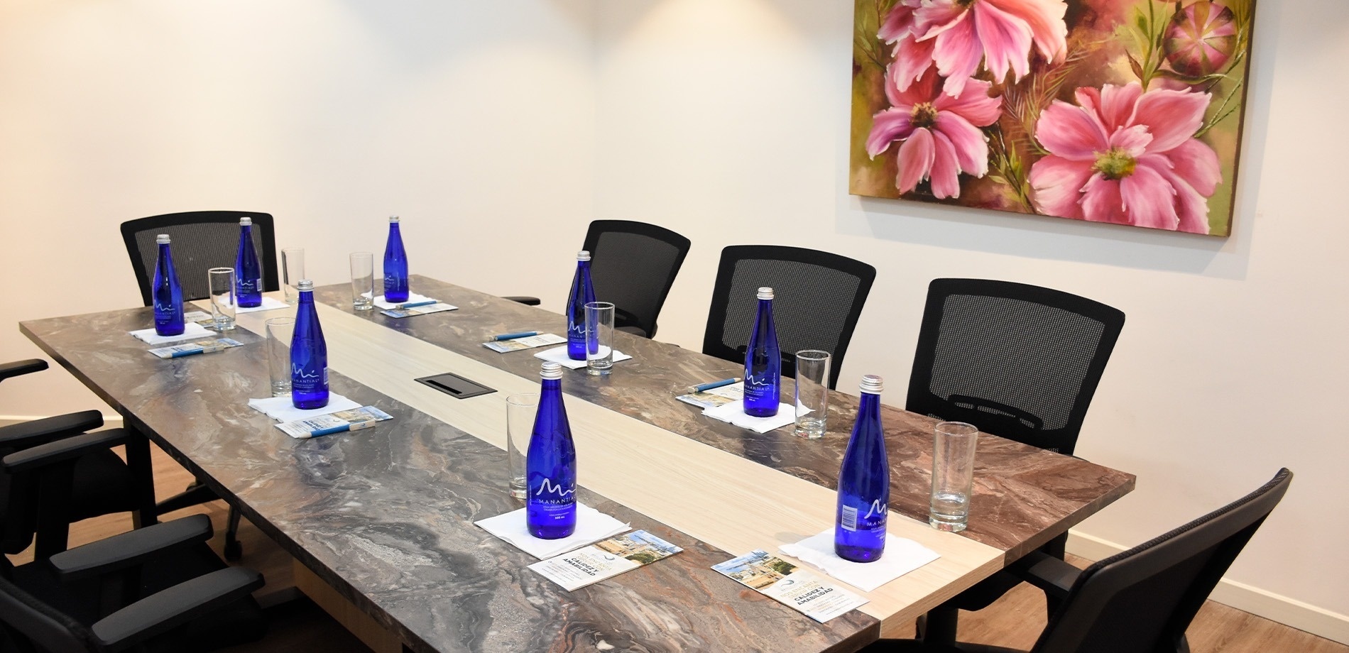a conference room with a painting of pink flowers on the wall