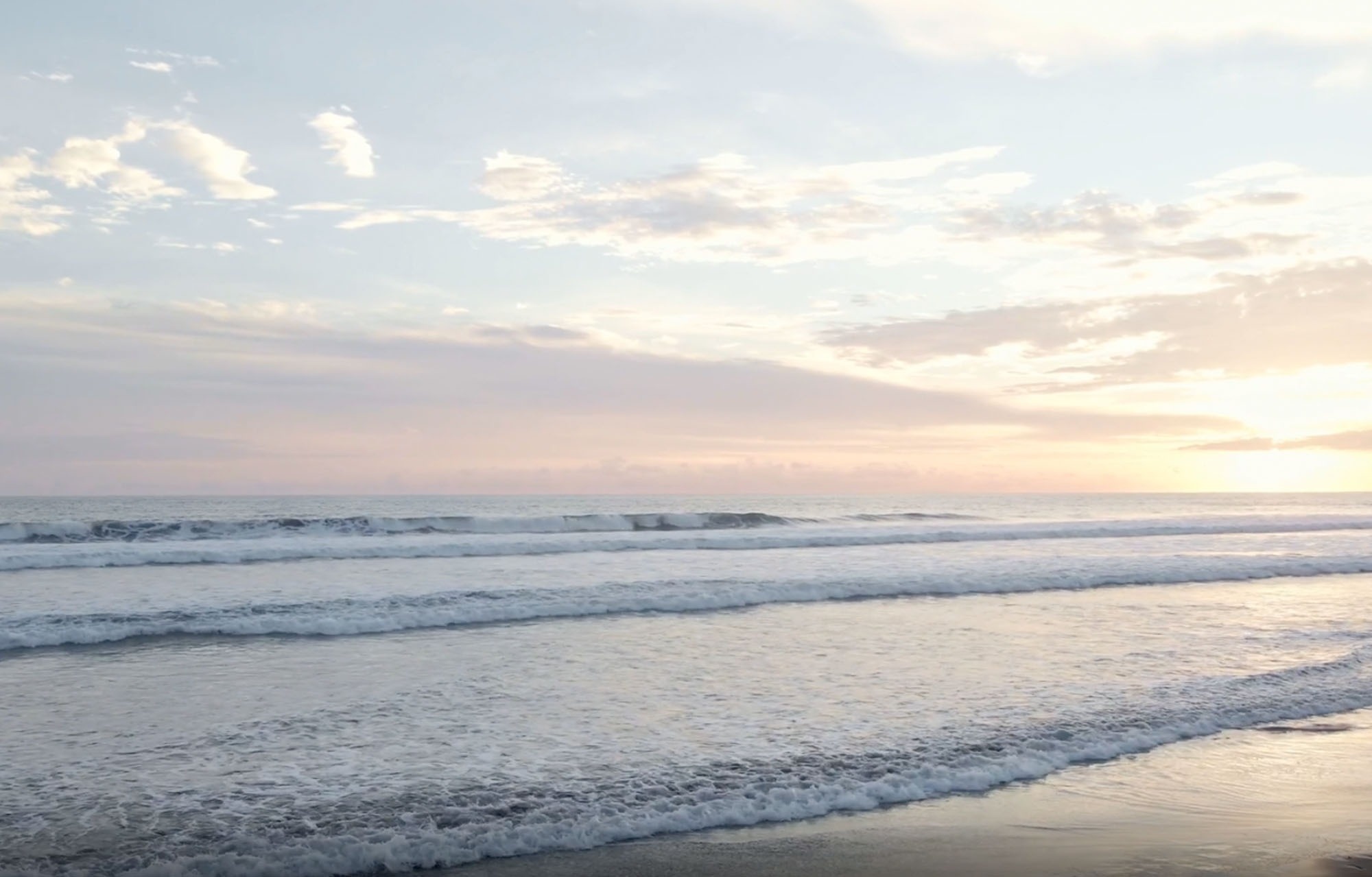 una mesa con un plato de frutas y dos copas de vino