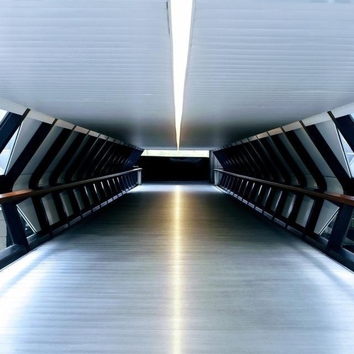 un largo pasillo que conduce a un edificio con muchas ventanas