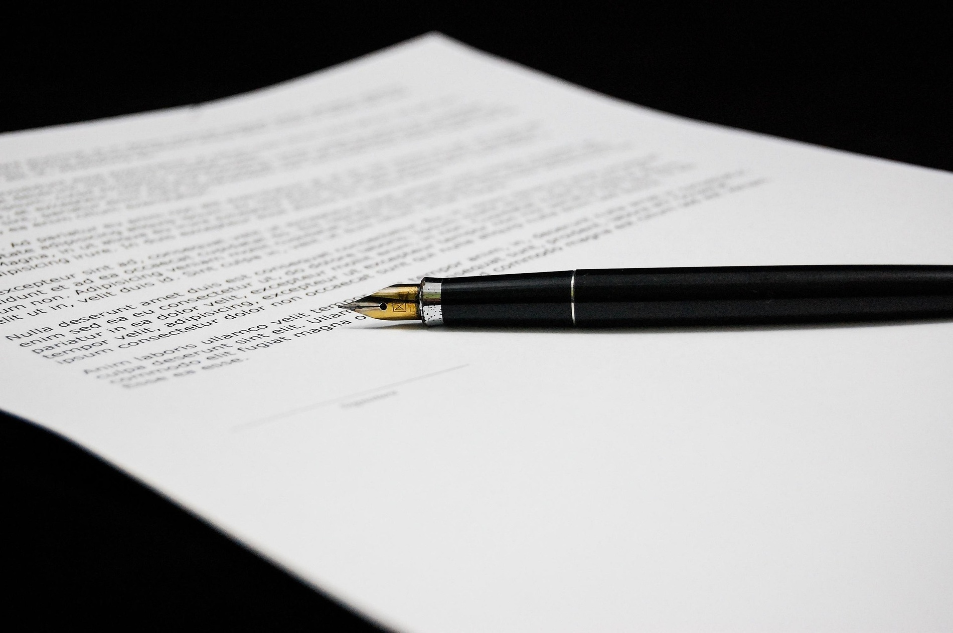un stylo noir est posé sur une feuille de papier