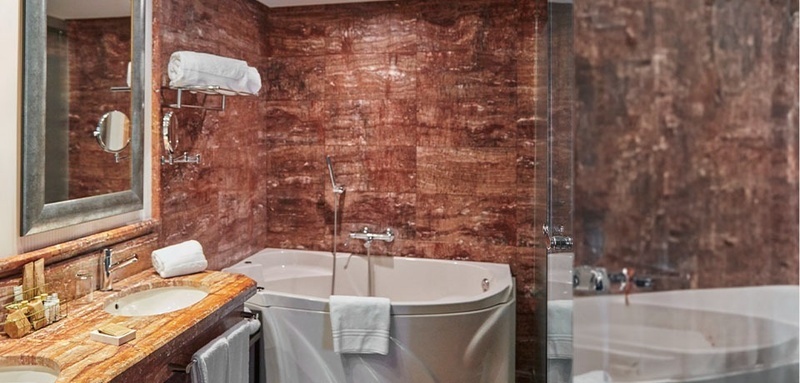 a bathroom with a corner tub and a sink