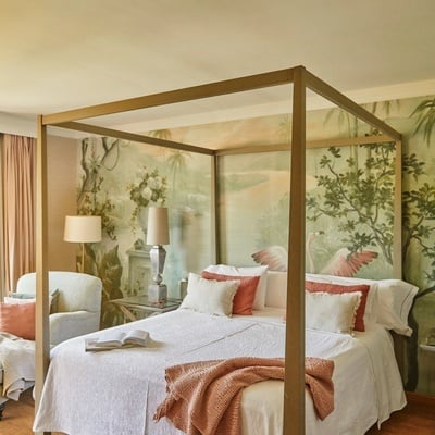 a bedroom with a canopy bed and a painting of flamingos on the wall