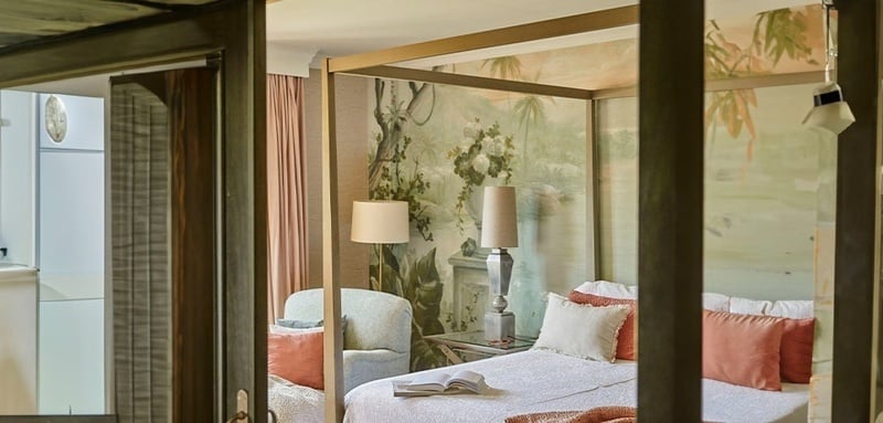 a bedroom with a canopy bed and a lamp