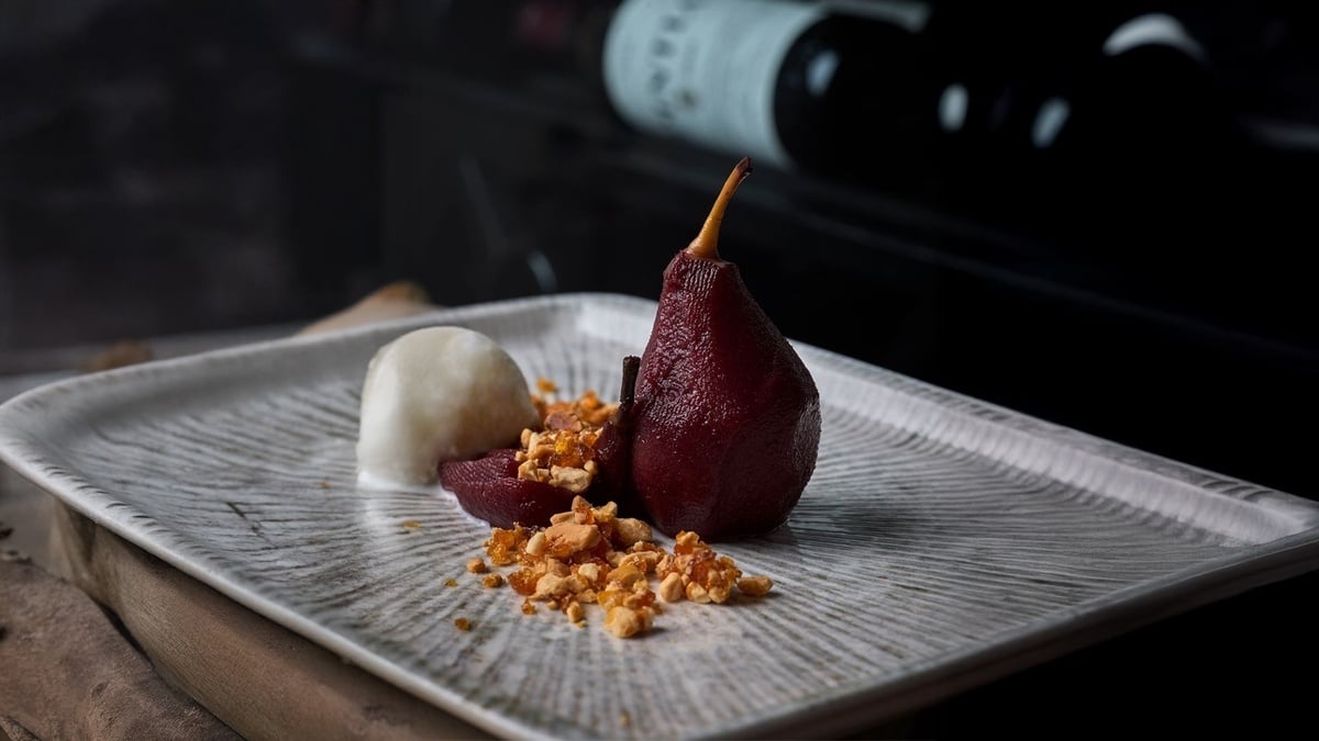 auf einem weißen teller steht eine rote birne neben einem weißen eiskugel
