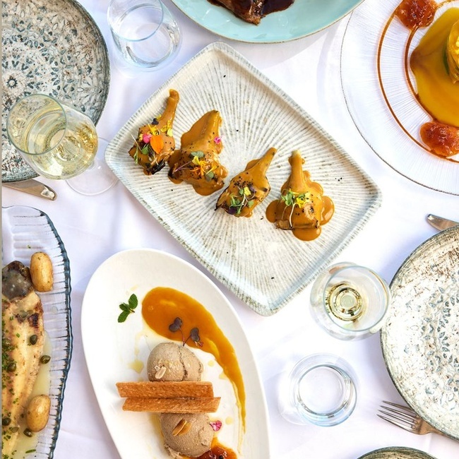 une table avec des assiettes de nourriture et des verres de vin