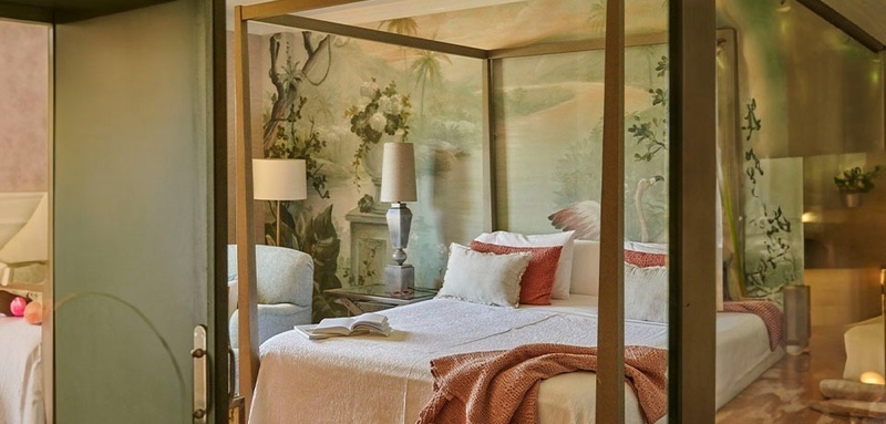 a bedroom with a canopy bed and a lamp