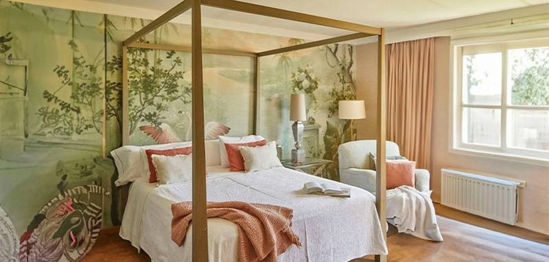 une chambre avec un lit à baldaquin et un fauteuil