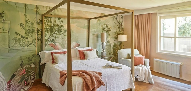 a bedroom with a canopy bed and a chair