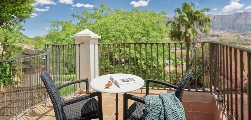 a balcony with two chairs and a table with a book on it