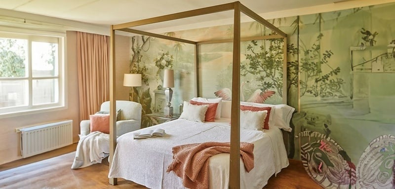 a bedroom with a canopy bed and a chair