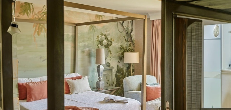 a bedroom with a canopy bed and a chair