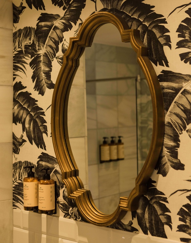 une salle de bain avec un miroir et des bouteilles de savon