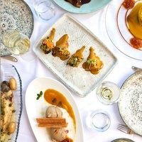 une table avec des assiettes de nourriture et des verres de vin