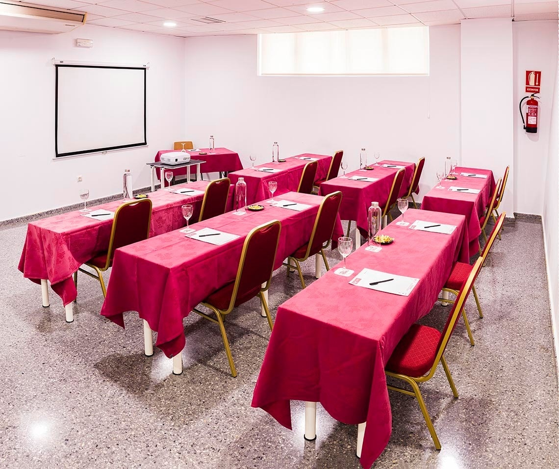 une salle de conférence avec des tables et des chaises avec des nappes roses