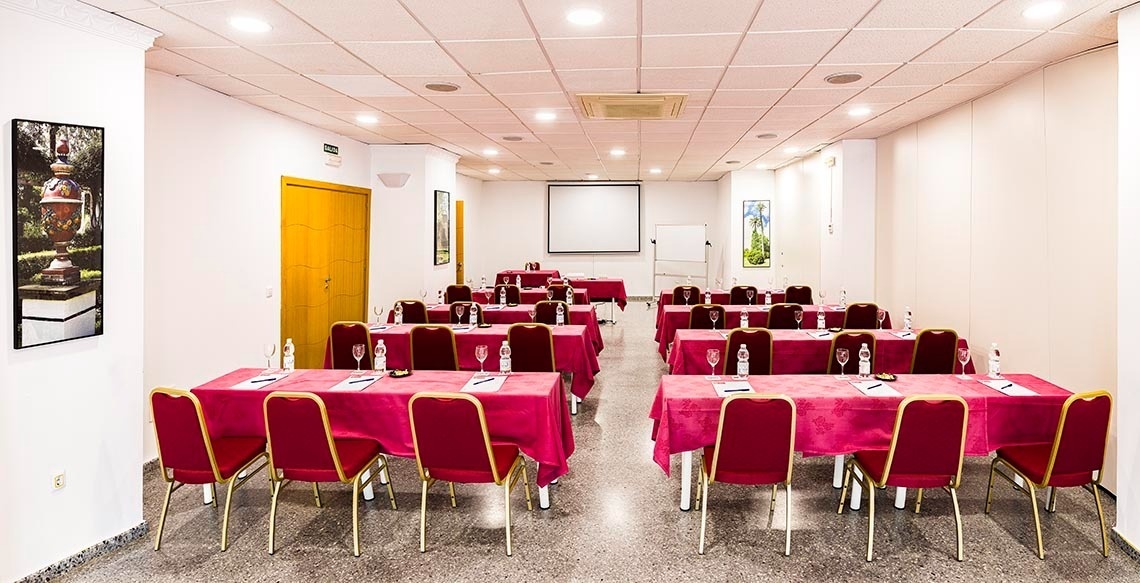 une salle de conférence avec des tables et des chaises rouges