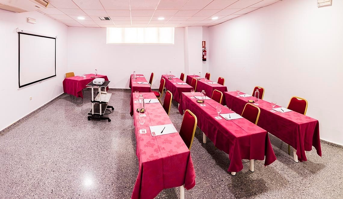 une salle de conférence avec des tables et des chaises et un projecteur