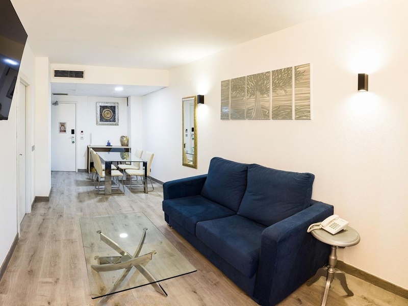 a living room with a blue couch and a glass coffee table