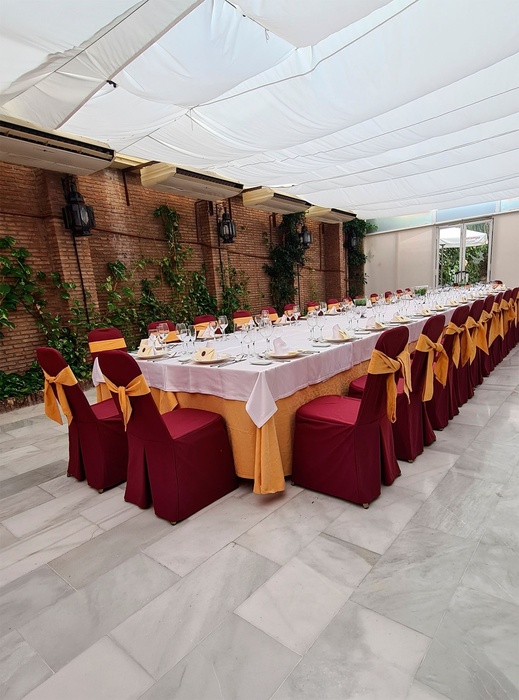 una mesa larga con sillas rojas y amarillas