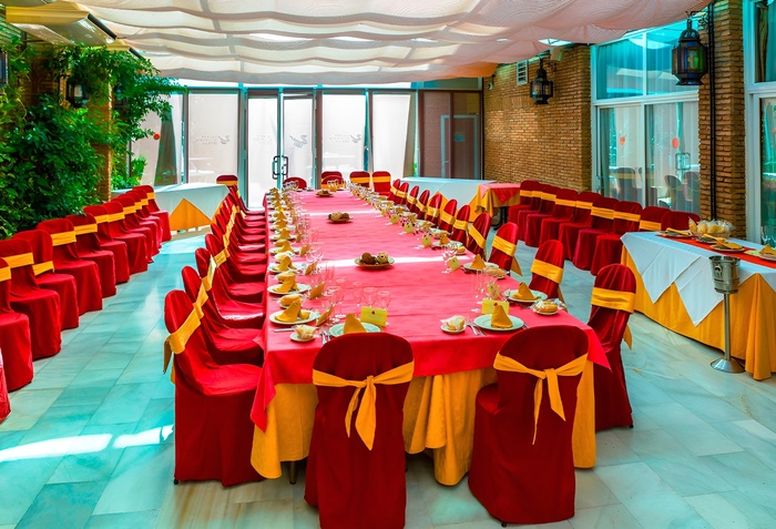 une longue table avec des chaises rouges et jaunes